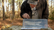 Tester examining a shot Clear Ballistics gel block at an outdoor range